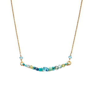 Dana Kellin Ocean Bar Necklace - Available at Shaylula Jewlery & Gifts in Tarrytown, NY and online. Simple and beautifully crafted, this Dana Kellin necklace is comprised of a spectrum of blue-hued gemstones intricately wrapped to a gently curved bar. The serene colors are reminiscent of the Caribbean ocean and will take your breath away.  • Turquoise, blue topaz, apatite, peridot, aquamarine,14k gold filled chain  • 14.5" L  • Lobster clasp