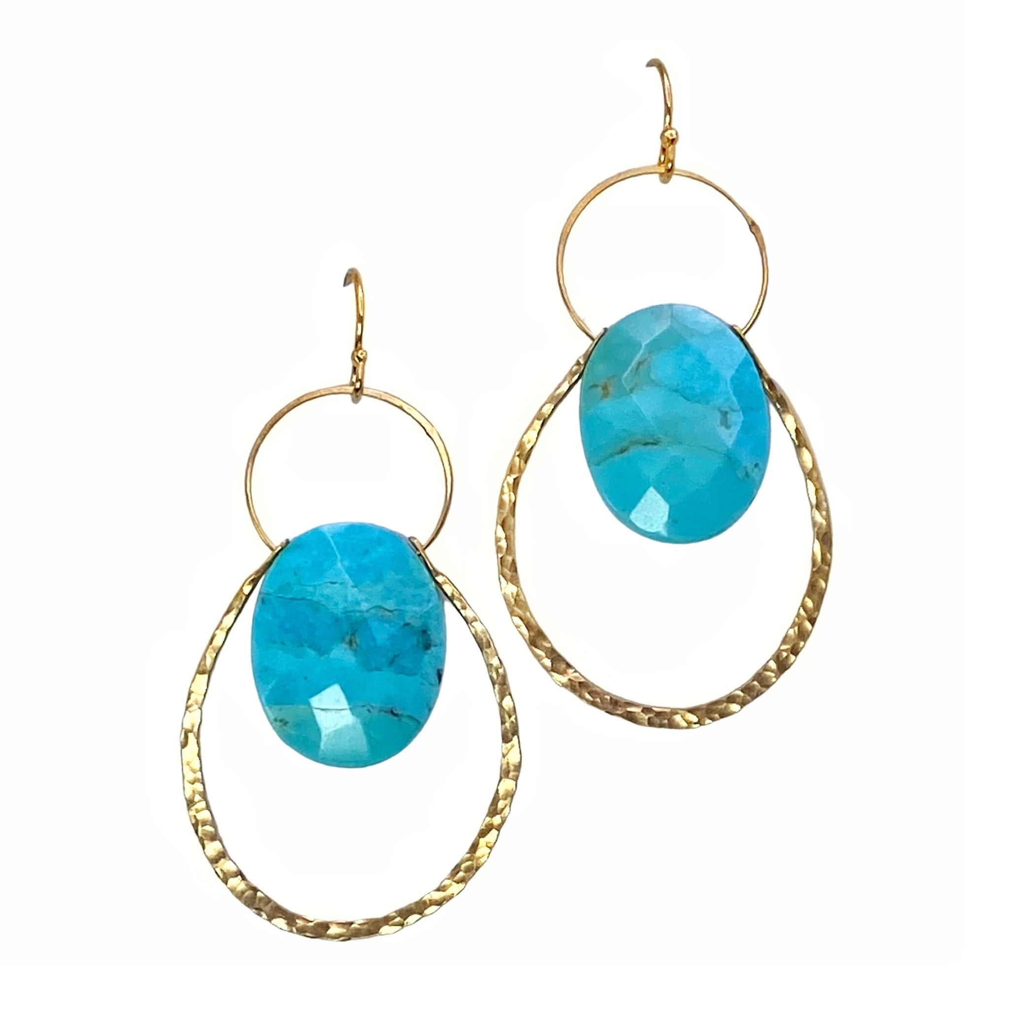 Lulu Designs Cali Earrings - Available at Shaylula Jewlery & Gifts in Tarrytown, NY and online.   A dramatic faceted turquoise oval gemstone floats in the center of two intersecting hammered gold hoops making them a refreshing statement earring that goes with everything! Made with love in Mill Valley, CA. (Model is wearing labradorite version.)  • Turquoise, 14k gold filled  • 1.75" L;  .71" L x  .51" W turquoise  • 14k gold fill earwire