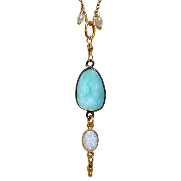 This handcrafted necklace by self-proclaimed California dreamer Robindira Unsworth, features a bright larimar and Australian opal pendant on a vermeil chain dotted with pearls. Larimar is commonly believed to be a calming stone, offering stillness, serenity, and all the cooling vibes you could ever wish for. Available at Shaylula Jewlery & Gifts in Tarrytown, NY and online.  • Larimar, Australian opal, fresh water pearl, 22k gold vermeil, sterling silver  • 18" L  • Shepard hook