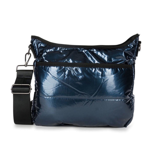 Haute Shore Perri Acme Puffer Crossbody available at Shaylula Jewlery & Gifts in Tarrytown, NY and online. This metallic blue puffer crossbody with top zip and hidden front pocket zipper is a favorite! Lined with an interior zip pocket and slots for ultimate organization. It includes 2 adjustable straps for mixing & matching - solid black and navy camo.  • 12.7" L × 4" W × 13.8" H