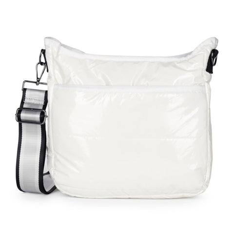 Haute Shore Perri Blanc Puffer Crossbody available at Shaylula Jewlery & Gifts in Tarrytown, NY and online. This vegan glossy white puffer crossbody with top zip and hidden front pocket zipper is a favorite! Lined with an interior zip pocket and slots for ultimate organization. It includes 2 adjustable straps for mixing & matching - silver with black stripes and beige camo.  • 12.7" L × 4" W × 13.8" H