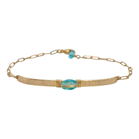 Dana Kellin Apatite Bar Bracelet is available at Shaylula Jewlery & Gifts in Tarrytown, NY and online. Apatite, known as a stone of manifestation, takes center stage on a lightly hammered gold bar where it is wire wrapped. The bracelet is completed with a delicate paperclip chain and accented with another apatite gem.  • 14k gold filled, apatite  • 7" L adjustable
