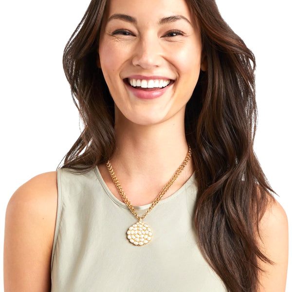 Julie Vos Mykonos Pendant Necklace Available at Shaylula Jewlery & Gifts in Tarrytown, NY and online. This fabulous necklace can be worn long or you can double the chain to wear it short. It features a mosaic of delicate oval gemstones and gold bead details. (Model is wearing Pearl)  • 24K gold plate, charcoal blue  • 18 - 36" L  • 1.5" Dia. pendant 